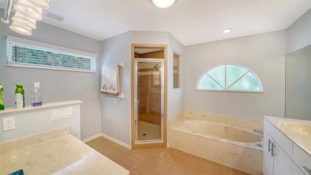 bathroom with vanity, a stall shower, tile patterned flooring, a garden tub, and baseboards