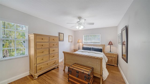bedroom with baseboards, light wood-style flooring, and ceiling fan