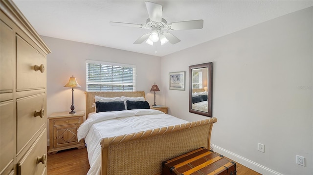 bedroom featuring light wood finished floors, baseboards, and a ceiling fan