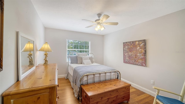 bedroom with light wood-style floors, baseboards, and a ceiling fan
