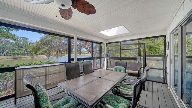 sunroom / solarium featuring a water view, ceiling fan, and a skylight