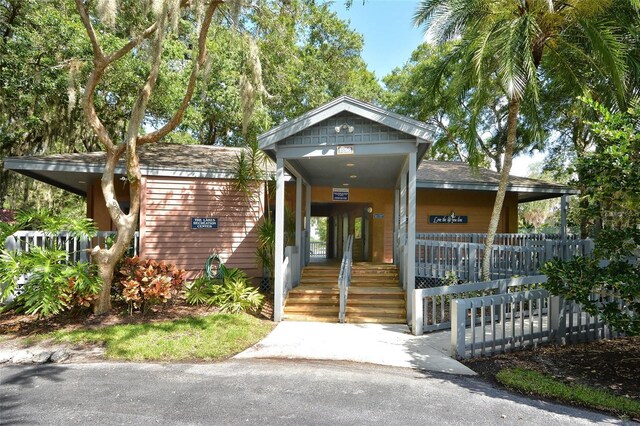 property entrance featuring covered porch and fence