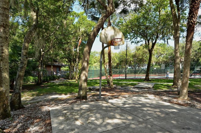 view of home's community featuring fence and basketball court