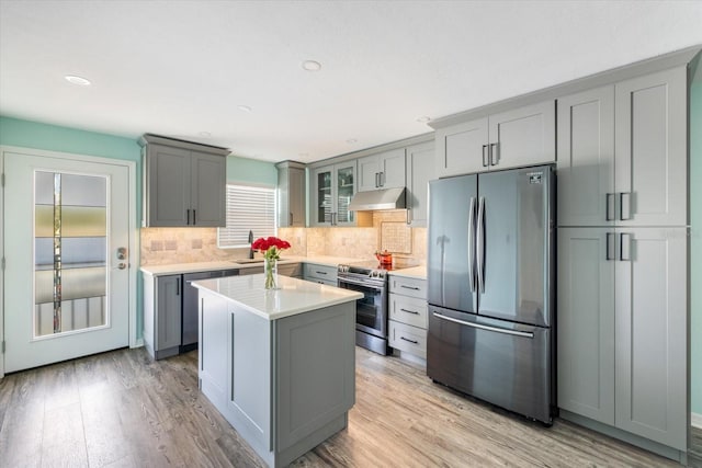 kitchen with stainless steel appliances, gray cabinets, under cabinet range hood, light countertops, and recessed lighting