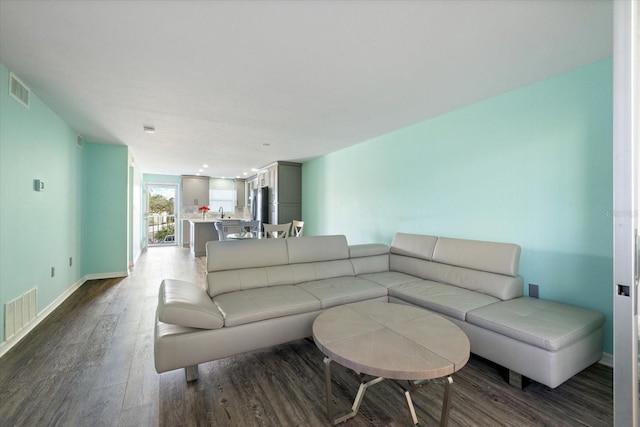 living area with dark wood-style flooring and baseboards