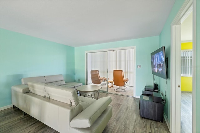 living room with wood finished floors, plenty of natural light, and baseboards