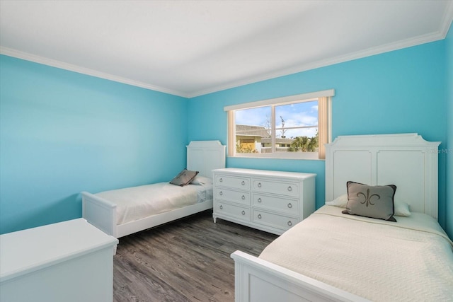 bedroom featuring crown molding and dark wood finished floors