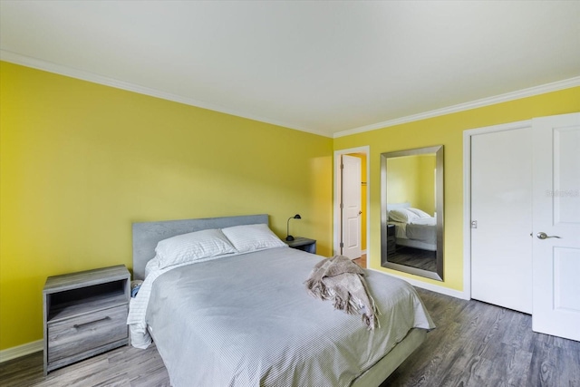 bedroom with wood finished floors, ornamental molding, and baseboards