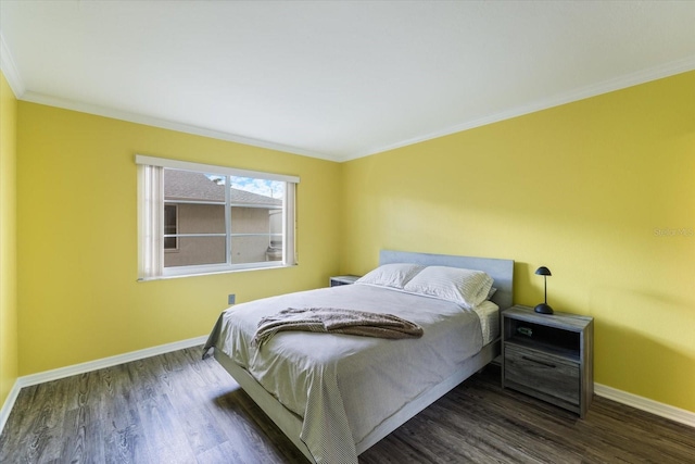bedroom with baseboards, ornamental molding, and wood finished floors