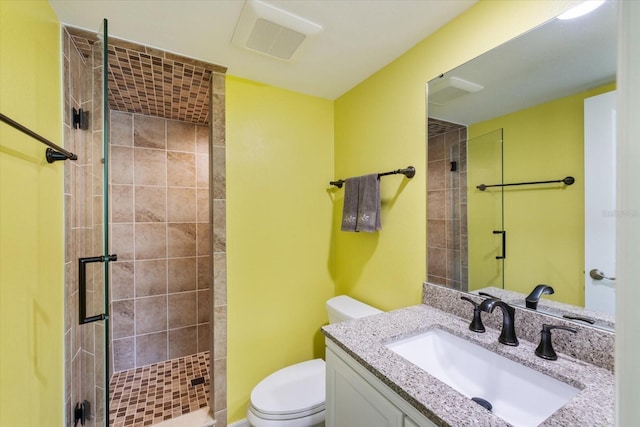 bathroom featuring a shower stall, toilet, and vanity