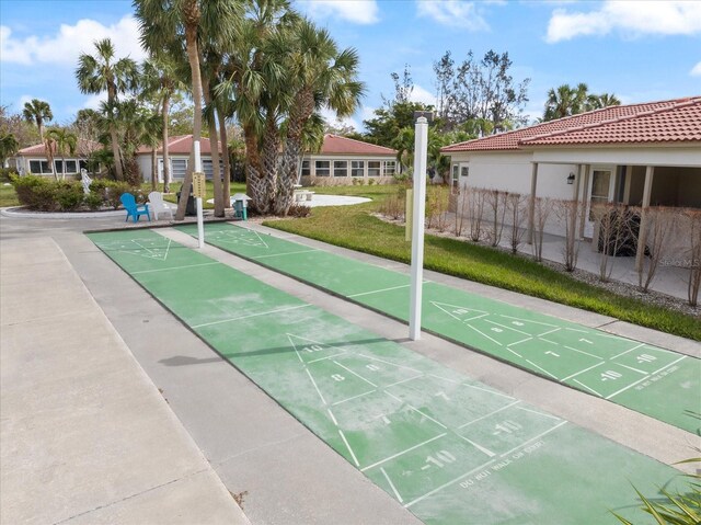 surrounding community featuring shuffleboard and a yard