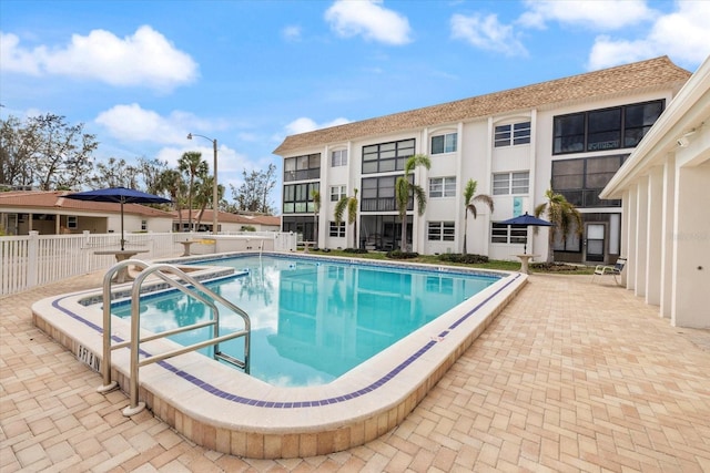 community pool with fence and a patio
