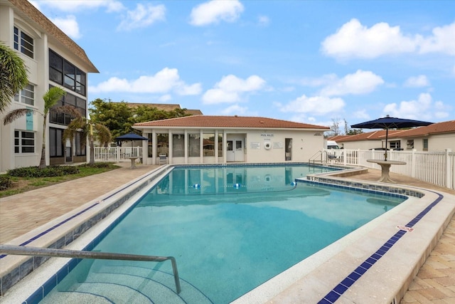 community pool with fence and a patio