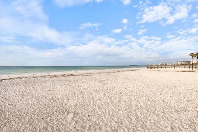 water view featuring local beach and fence