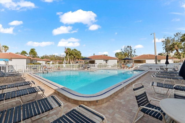 community pool featuring fence and a patio