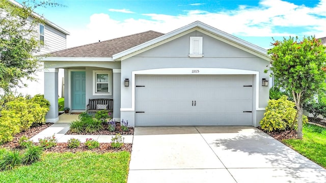view of front of home with an attached garage, a shingled roof, driveway, and stucco siding