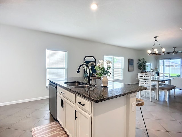 kitchen featuring a sink, plenty of natural light, stainless steel dishwasher, and light tile patterned flooring
