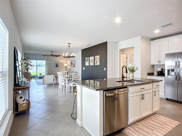 kitchen featuring appliances with stainless steel finishes, a sink, a kitchen island with sink, a ceiling fan, and light tile patterned flooring