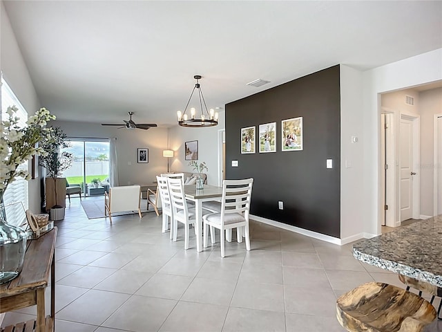 dining room with a chandelier, a ceiling fan, light tile patterned floors, and baseboards