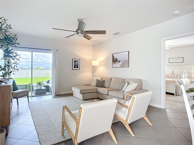 living room with ceiling fan, tile patterned flooring, and baseboards