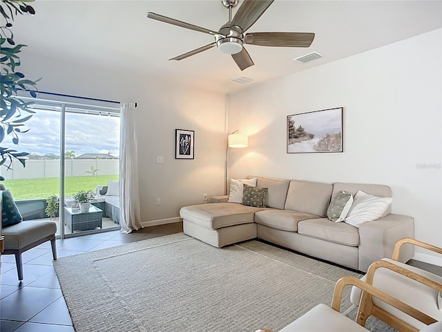 tiled living room featuring ceiling fan and baseboards