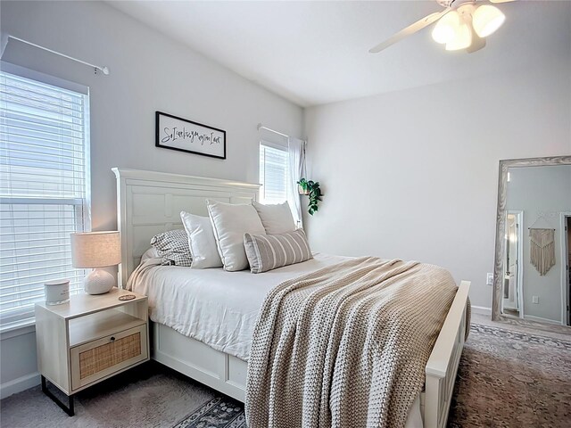 carpeted bedroom featuring baseboards and ceiling fan