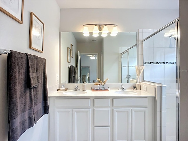 bathroom featuring a shower stall, double vanity, and ceiling fan