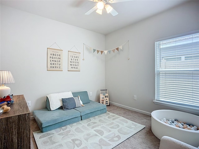 carpeted living room featuring ceiling fan, healthy amount of natural light, and baseboards