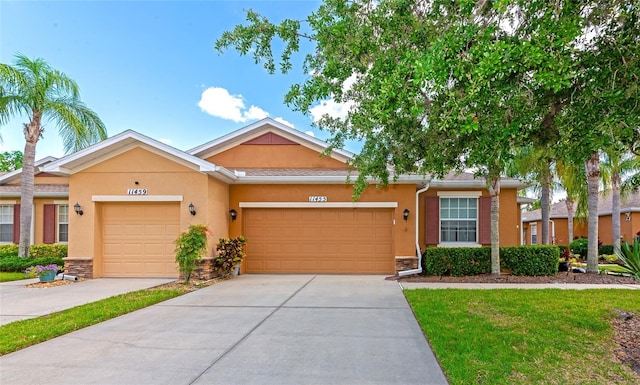 11455 52nd Ct E, Parrish, FL 34219 - townhome / multi-family property featuring stucco siding, driveway, a garage, and a front yard