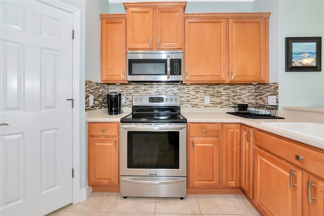 11455 52nd Ct E, Parrish, FL 34219 - kitchen featuring appliances with stainless steel finishes, light countertops, tasteful backsplash, and light tile patterned floors