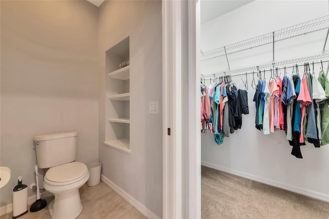 11455 52nd Ct E, Parrish, FL 34219 - bathroom featuring toilet, a spacious closet, baseboards, and tile patterned flooring