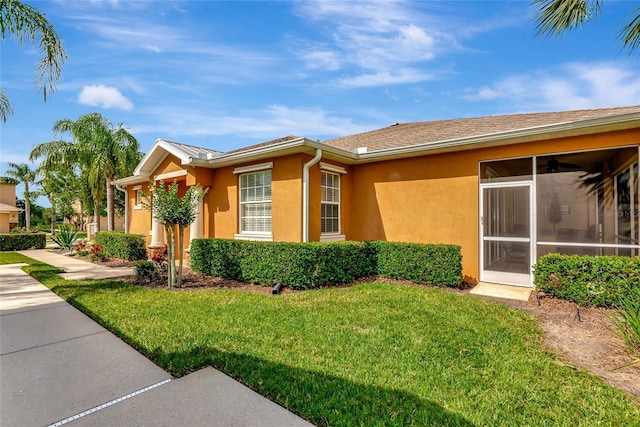 11455 52nd Ct E, Parrish, FL 34219 - view of side of home with a lawn, stucco siding, and a sunroom