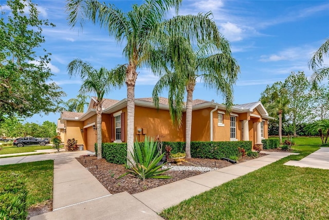 11455 52nd Ct E, Parrish, FL 34219 - view of front of house with driveway, stucco siding, a front lawn, and a garage