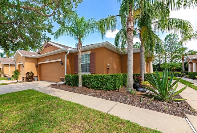 11455 52nd Ct E, Parrish, FL 34219 - view of front of property featuring stucco siding, a garage, driveway, and a front lawn