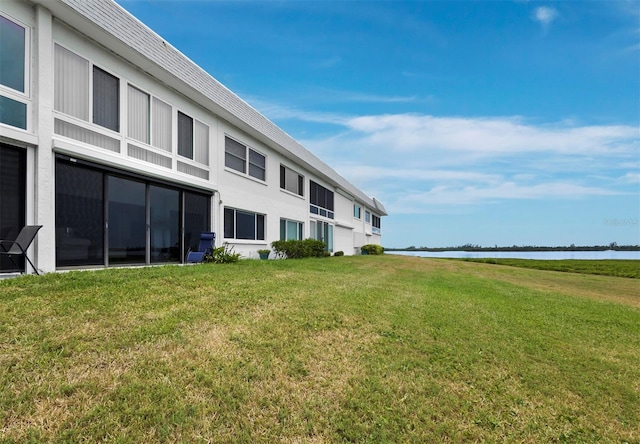 back of house with a yard and a water view
