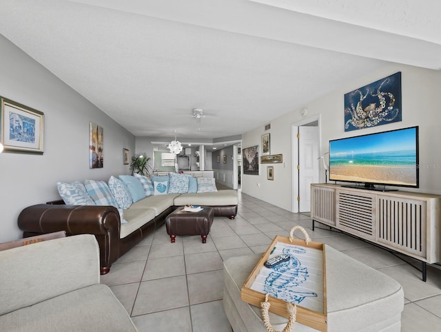 living area with tile patterned floors, a ceiling fan, and a chandelier