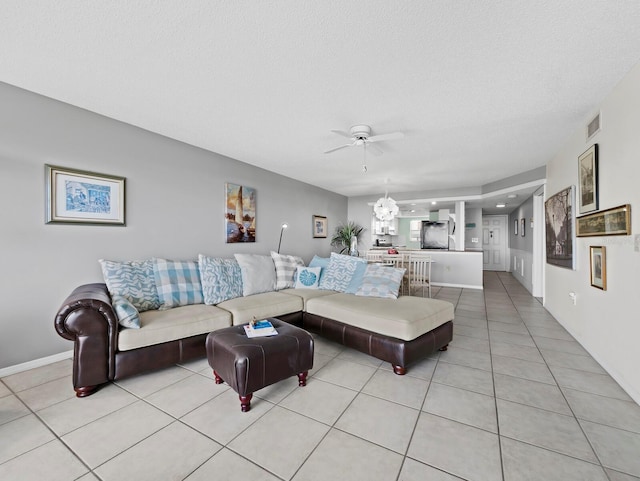 living area featuring a ceiling fan, light tile patterned floors, and baseboards