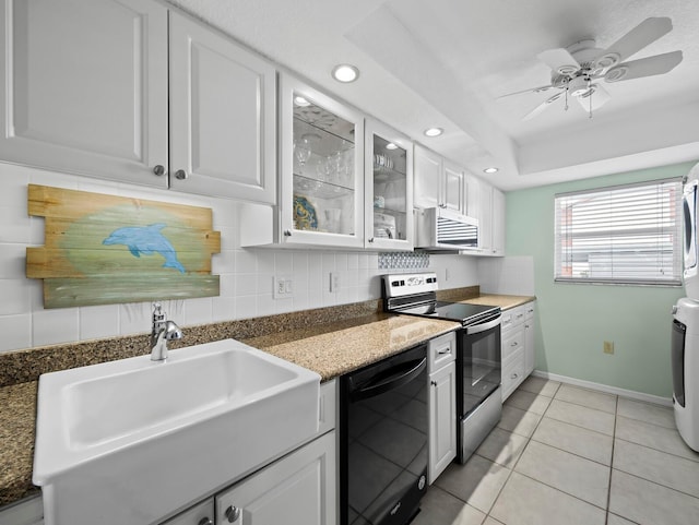 kitchen with dishwasher, stainless steel range with electric stovetop, stacked washer and clothes dryer, a sink, and recessed lighting