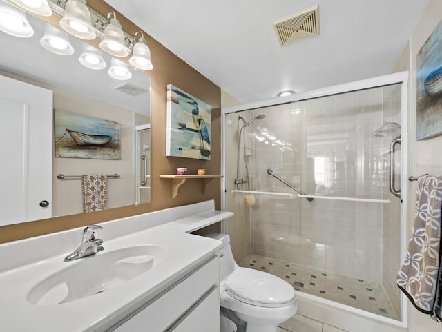 full bathroom featuring a stall shower, toilet, and vanity