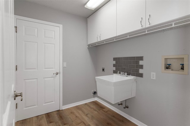 laundry room featuring cabinet space, hookup for an electric dryer, washer hookup, light wood-style floors, and baseboards