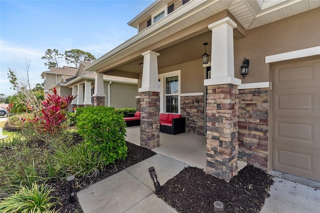 doorway to property featuring a porch, stucco siding, and stone siding