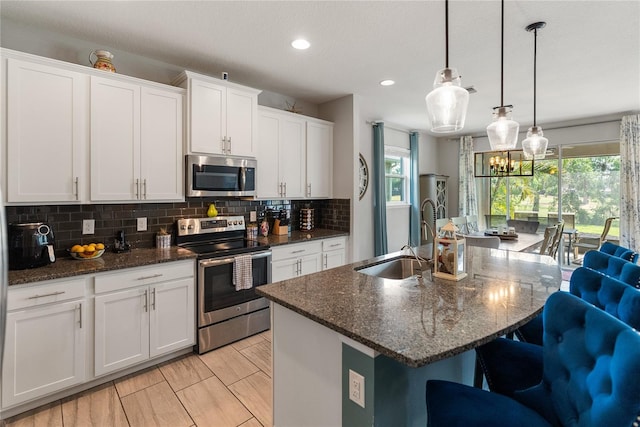 kitchen with stainless steel appliances, a sink, plenty of natural light, tasteful backsplash, and recessed lighting