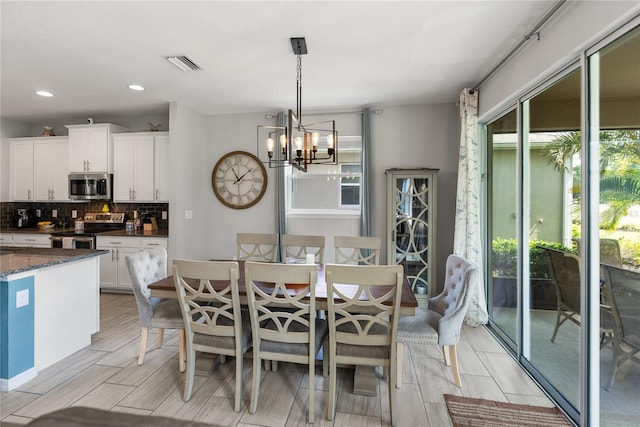 dining area with healthy amount of natural light, a chandelier, wood finish floors, and recessed lighting