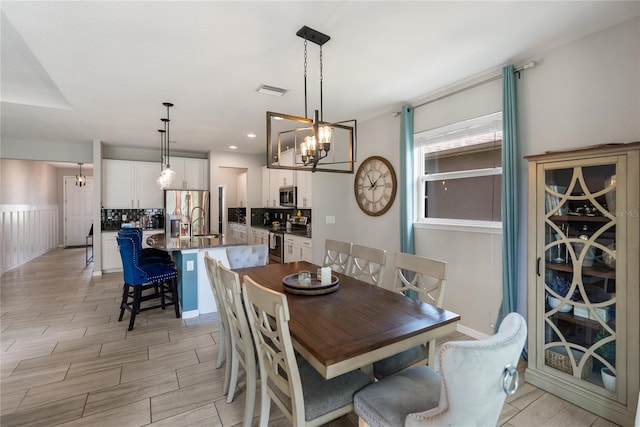 dining space featuring a chandelier, wood finish floors, and recessed lighting