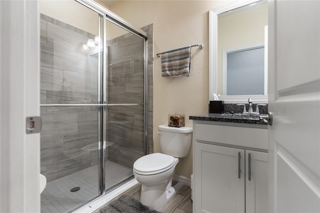 full bathroom with toilet, a stall shower, and vanity