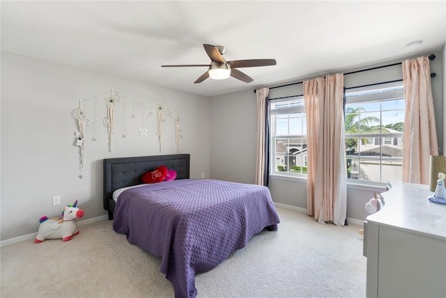 bedroom featuring light colored carpet, ceiling fan, and baseboards