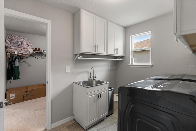 laundry room featuring washing machine and clothes dryer, cabinet space, and baseboards