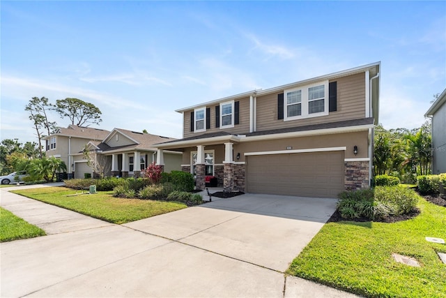 view of front of home with a front lawn, an attached garage, concrete driveway, and stone siding