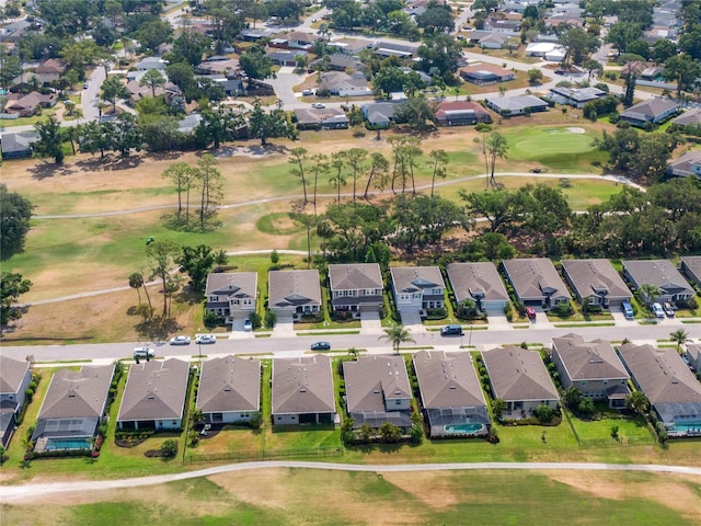 aerial view of property and surrounding area featuring nearby suburban area and a golf course