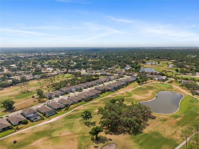aerial view of property's location featuring nearby suburban area, a nearby body of water, and a local golf course